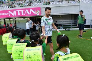 写真:選手とハイタッチする子どもたち