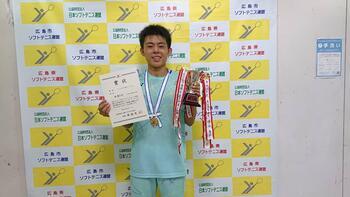 Foto: El Sr. Minami sosteniendo el certificado y la copa del campeón