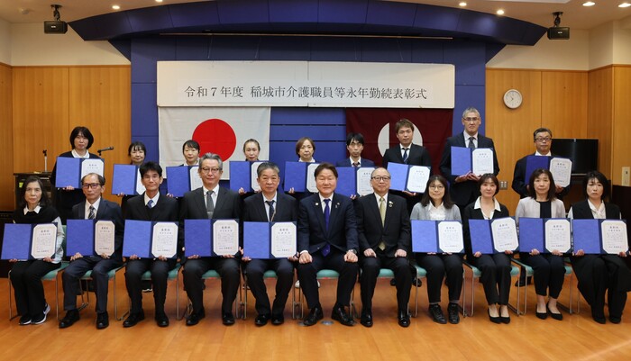 Esta é uma foto em grupo dos 18 participantes da cerimônia de premiação com o prefeito Takahashi e o vice-prefeito Ishida.