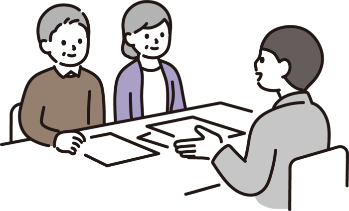 Um homem está sentado à mesa, fazendo uma proposta para um casal.